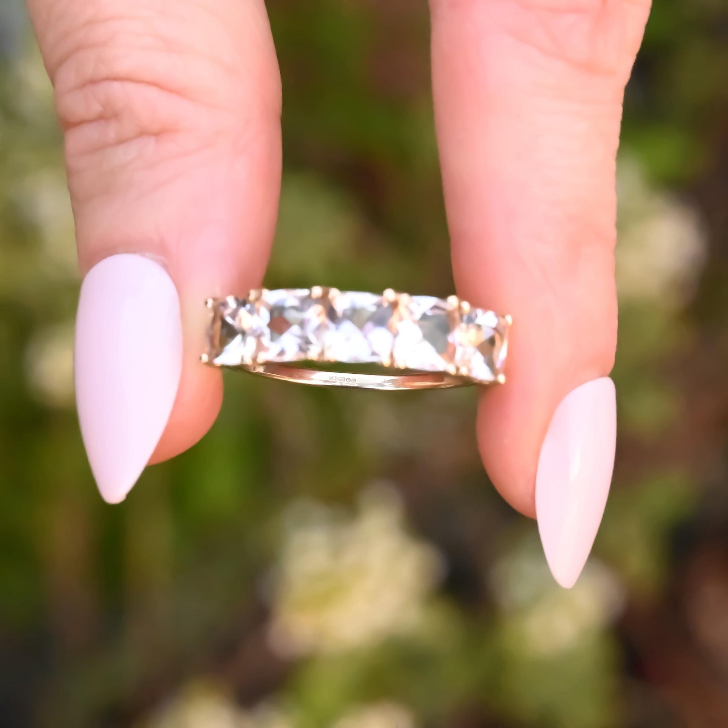 pretty morganite ring held between two fingers