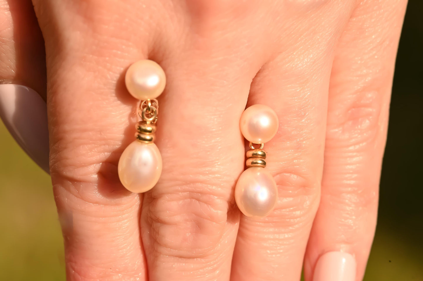 for scale, earrings held in hand, lively dangle drop stud pearl earrings in hallmarked 9ct solid gold in unusual design - elegant and dainty vintage jewellery.