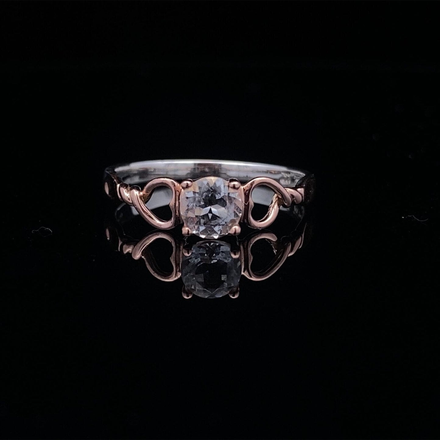 on black surface, ring shines beautifully showing the clear white topaz