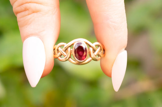 rich ruby red Celtic ring shown in hands