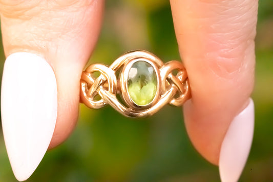 pretty peridot Celtic ring, shown in hand - bright stone with rare Clogau Welsh gold in 9ct yellow and rose gold.