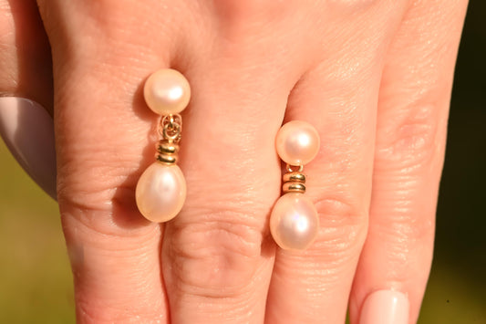 for scale, earrings held in hand, lively dangle drop stud pearl earrings in hallmarked 9ct solid  gold in unusual design - elegant and dainty vintage jewellery.